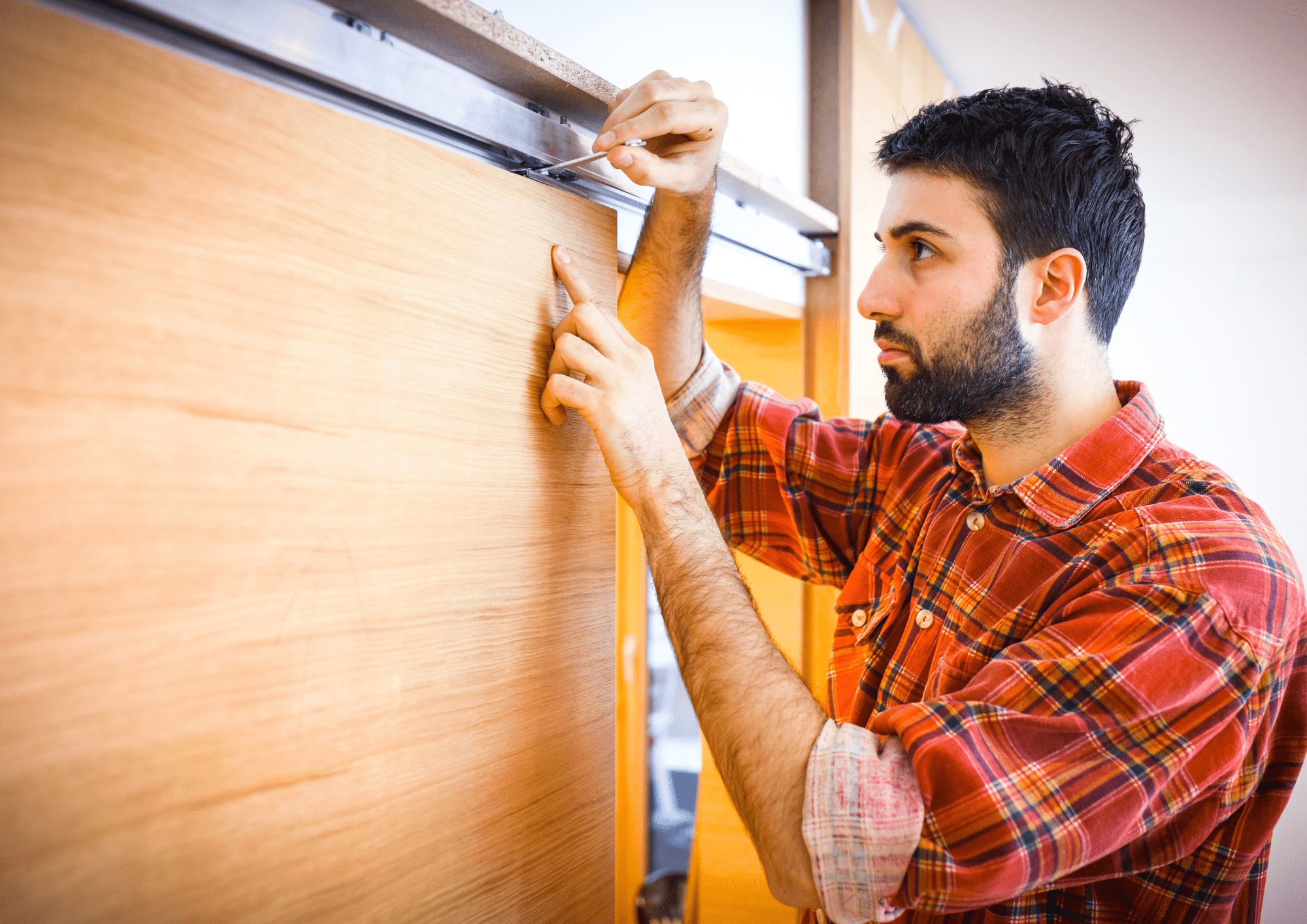 Trabajador midiendo una puerta para instalarla a medida en una casa situada en Sant Cugat