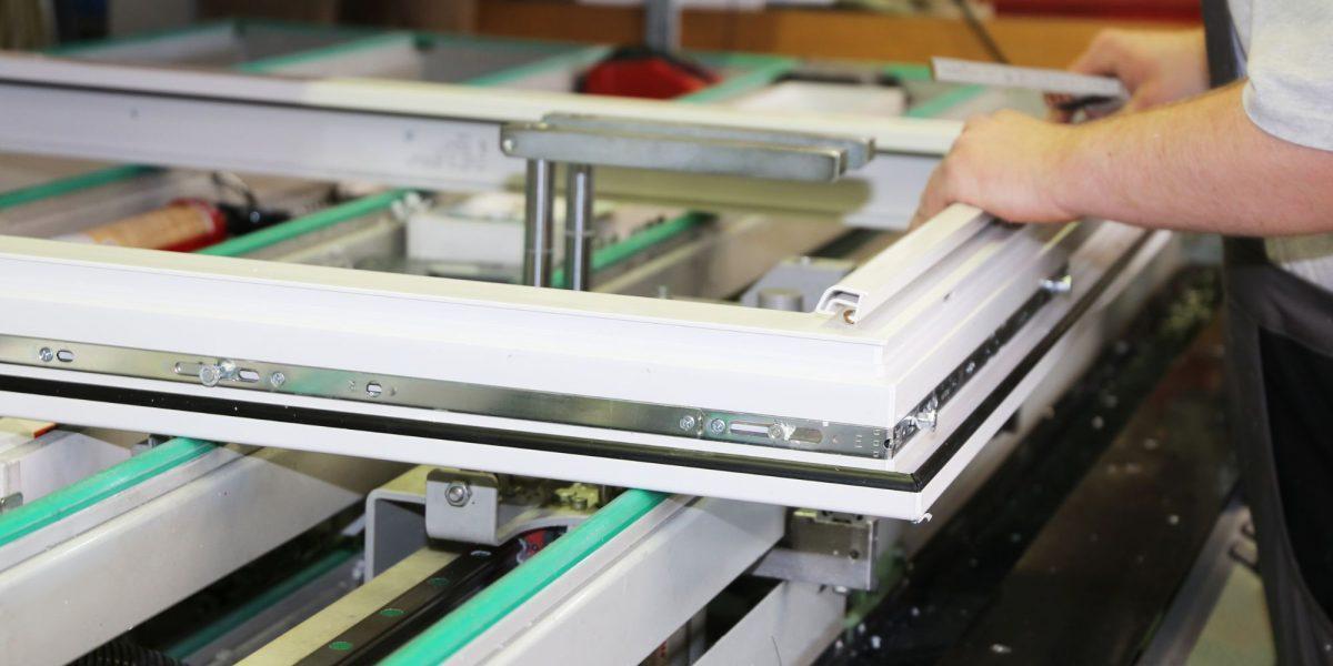 Trabajador experto realizando el proceso de carpintería de aluminio en una ventana para instalarla