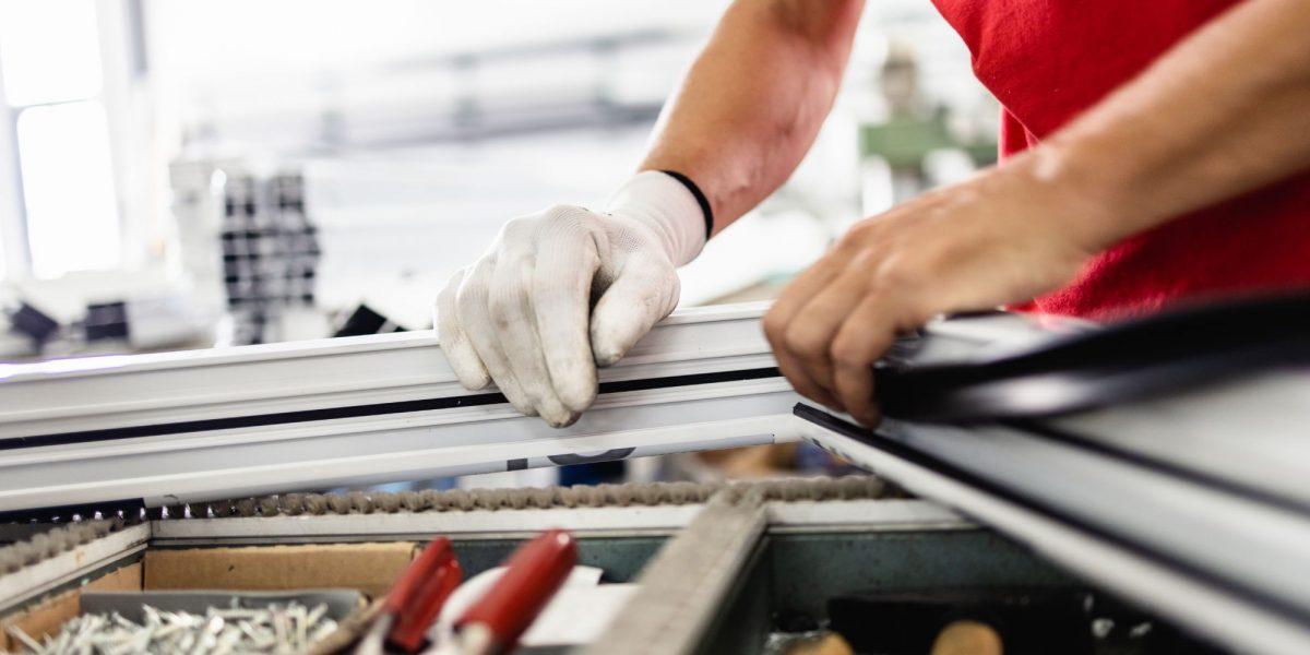 Trabajador experto reparando y fabricando ventana a medida