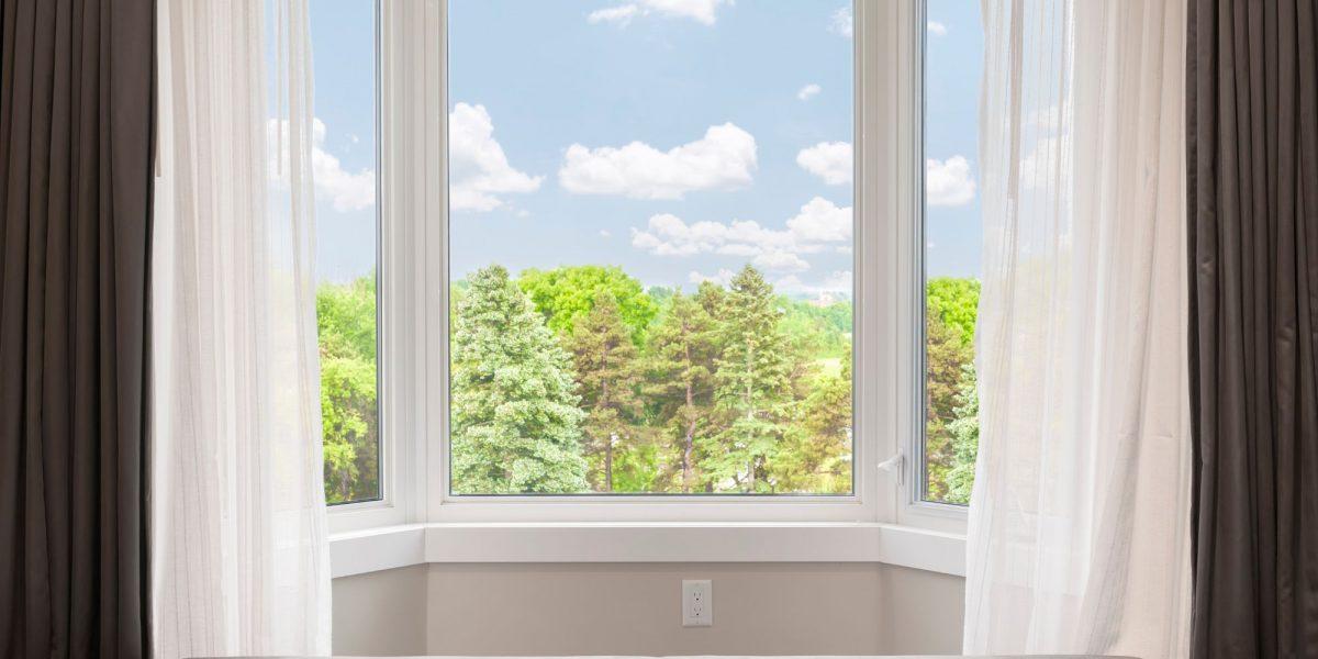 Ventanas abatibles de una casa con cortinas que se utilizan para tapar el exceso de luz solar