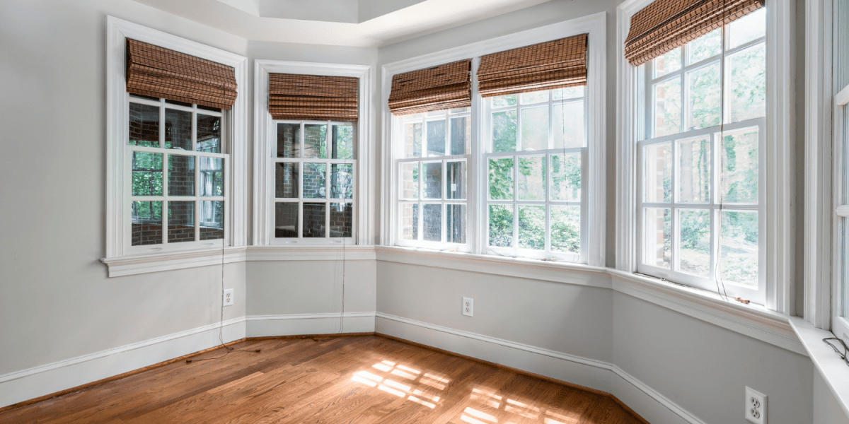 Conjunto de ventanas de una casa que se encuentran cerradas y con las cortinas subidas donde se puede apreciar la luz natural que entra